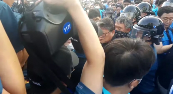 25일 오전 조원진 우리공화당 공동대표가 용역과 경찰 사이에 둘러싸여 밖으로 나가고 있다. 서울시는 이 과정에서 조 공동대표가 폭행을 했다고 주장했다.