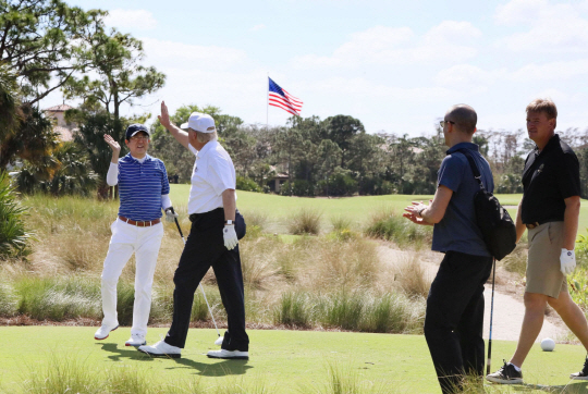 미국 트럼프 대통령과 일본 아베 수상이 골프를 치면서 하이파이브를 하고 있다.