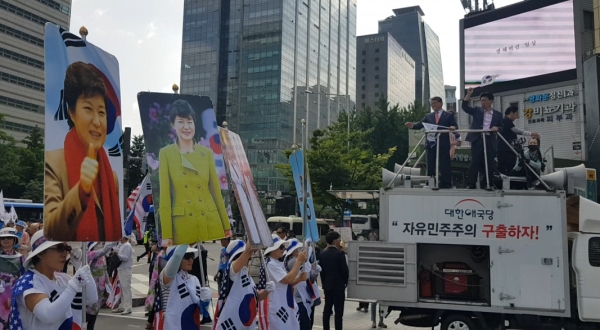 우리공화당 당원들이 집회 후 박근혜 대통령 석방을 요구하는 대형 피켓을 들고 행진 하고 있다.