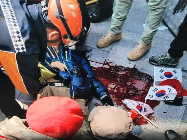 지난 2017년 3월10일 서울 종로 헌법재판소 입구에서 헌재의 탄핵선고에 저항하다가 공권력에 의해 쓰러진 한 애국열사. 바닥에는 피가 흐르고 있다.