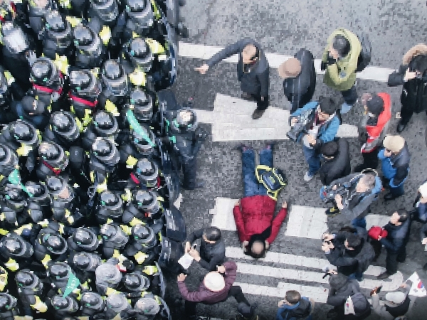 지난 2017년 3월10일 서울 종로 헌법재판소 입구에서 헌재의 탄핵선고에 저항하다가 공권력에 의해 쓰러진 한 애국열사. 경찰에 둘러싸여 있다.