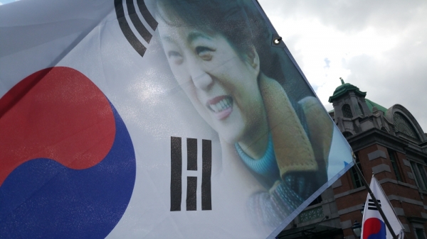 한 태극기 집회에서 태극기에 박근혜 대통령 얼굴이 그려져 있는 현수막을 들고 있다.